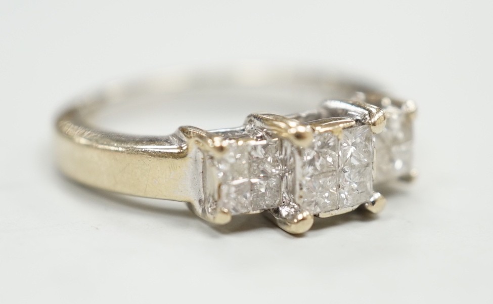 A modern 18ct white gold and triple princess cut diamond cluster set dress ring, size K, gross weight 5 grams.